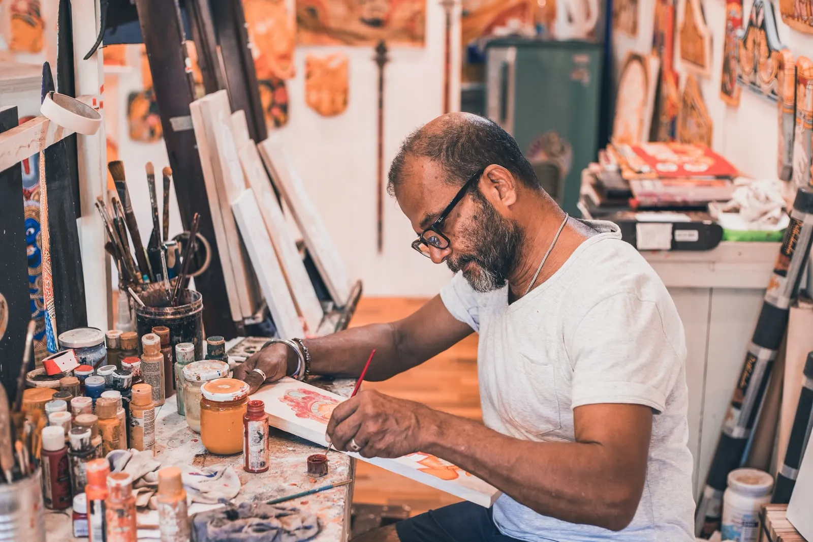 Painter at work in his studio, surrounded by brushes and colours